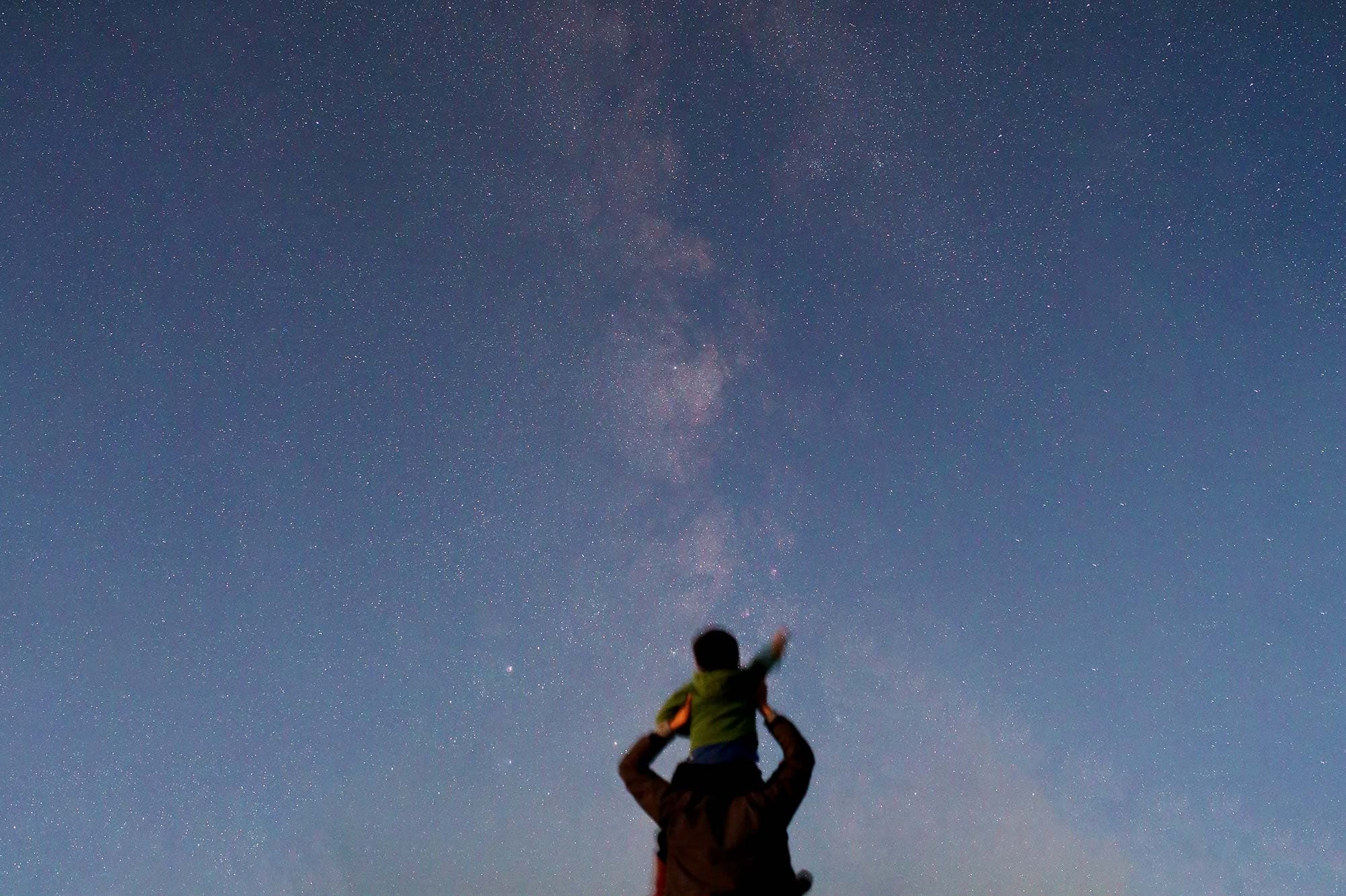 A child pointing at stars and galaxies